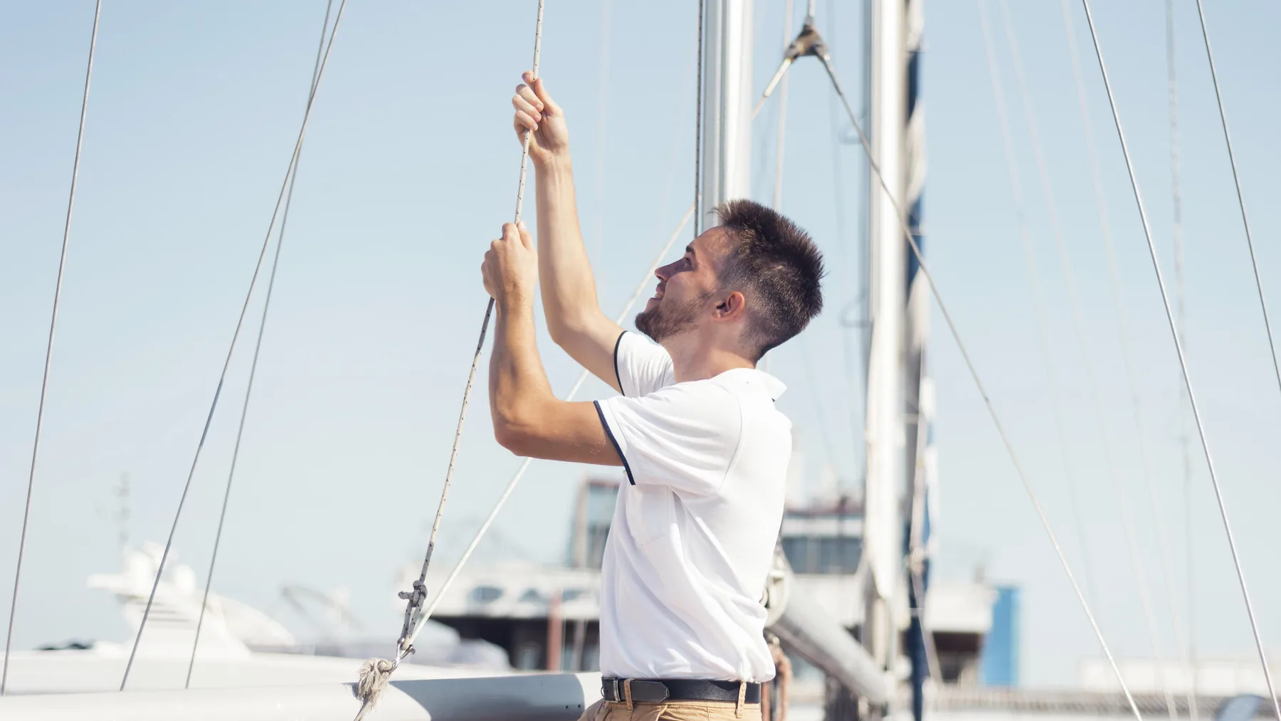Propietario revisando el aparejo de un velero durante una valoración comercial de barco de segunda mano